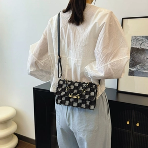 Sac bandoulière chic en tweed à carreaux noir et blanc avec détail de chaîne élégante