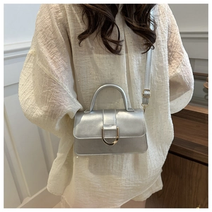 Silver metallic PU leather handbag with gold D-buckle detail shown on model