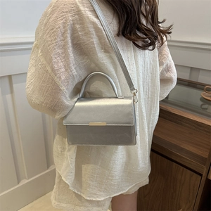 Silver metallic leather shoulder bag with gold hardware and top handle for women
