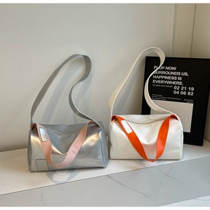 Close-up of stylish contrast color pillow bags in metallic silver and white leather