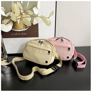 Detail of minimalist nylon crossbody bags with dual zippers and adjustable straps