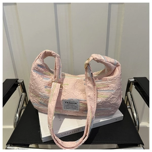 Detail of pink quilted handbag showing wave texture and colored lines with fashion label