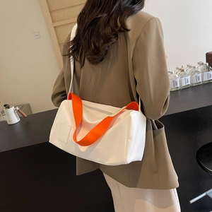 White Boston bag with orange handles worn by model in a casual business style