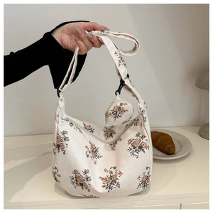 Detail of floral corduroy shoulder bag featuring a matching round coin purse and soft texture