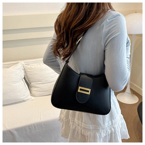 Side view of a black crescent shoulder bag featuring a prominent gold rectangular metal buckle