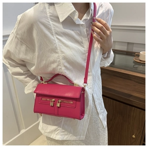 Dettaglio mini borsa fucsia a tracolla con cerniere dorate e ciondolo a forma di lucchetto