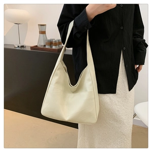 Detail of off-white hobo bag showing minimalist geometric paneling on large shoulder tote