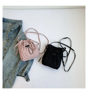 Détail de sacs seaux minimalistes en nylon à cordon en rose et noir avec bandoulières