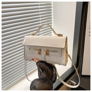 Dettaglio borsa bianca in pelle con doppie cerniere decorative e lucchetto dorato inciso