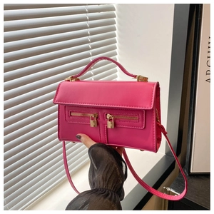 Dettaglio della borsa rosa vivace in ecopelle con doppia cerniera e lucchetto dorato quadrato