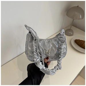 Nahaufnahme der silbernen Plissee-Tasche mit metallischer Schmetterlingsschnalle