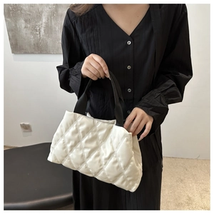 Gros plan du sac fourre-tout matelassé blanc avec anses noires pour la mode d'hiver