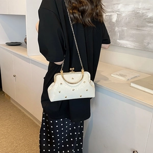 Elegant cream glossy crossbody bag with gold heart studs and vintage metal frame clasp
