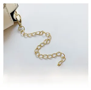Detail of white leather shoulder bag with golden chain strap and lobster clasp hardware