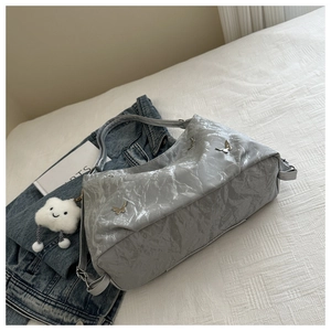 Détail du sac fourre-tout argenté avec papillons métalliques et texture plissée