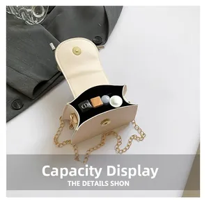 Detail of elegant cream crossbody bag with gold chain showing interior storage capacity