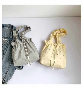 Close-up of drawstring bucket bags with rhinestone accents and ruffled shoulder straps
