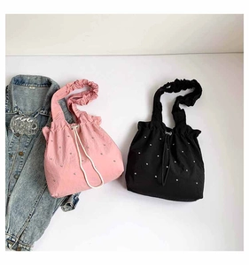 Close-up of pink and black drawstring tote bags with sparkling rhinestone decorations