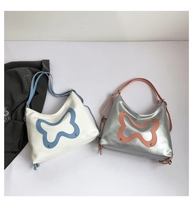 Close-up of butterfly embroidery detail and silver studs on PU leather shoulder bags