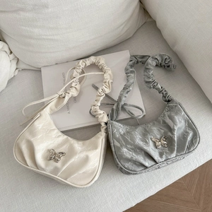 Schicke Hobo-Tasche mit Raffung und silberner Schmetterlingsschnalle in Creme und Silber