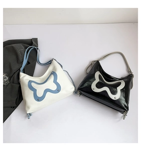 Detail of solid color butterfly design shoulder bags with metallic rivets and PU leather