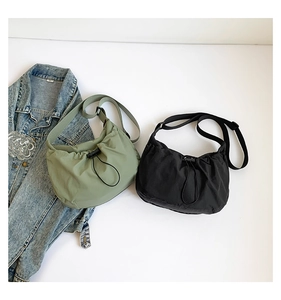 Detail of waterproof nylon hobo bags with drawstring closure in dark green and black