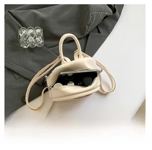 Vue détaillée de l'intérieur d'un mini sac à dos beige montrant sa capacité de rangement