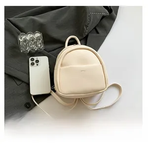 Vue détaillée du mini sac à dos en cuir crème avec le logo de la marque aimal gravé