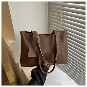 Detail der dunkelbraunen Leder-Tote-Bag mit Kontrastnähten und Metallnieten-Akzenten
