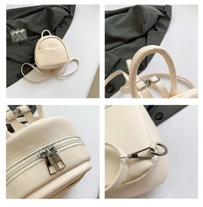 Détails du mini sac à dos blanc crème montrant les zips et les crochets métalliques