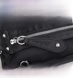 Detail of silver metal zipper with black pebble leather puller and embossed logo