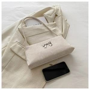 Détail du sac à bandoulière blanc cassé avec texture marbre et boucle nœud argentée
