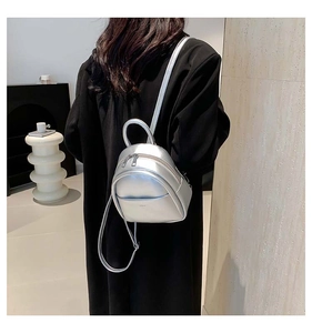 Détail d'un mini sac à dos argenté métallisé avec fines bretelles et poignée