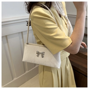 Détail d'un sac à bandoulière en cuir blanc avec boucle nœud sur un mannequin