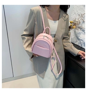 Modèle avec mini sac à dos en cuir rose clair et poches zippées pour un look estival