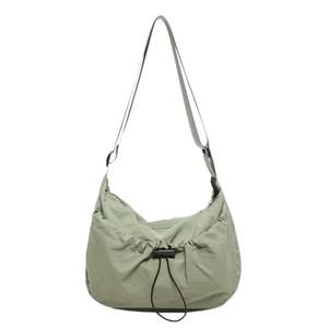 Minimalist sage green nylon crossbody bag with drawstring closure and adjustable strap