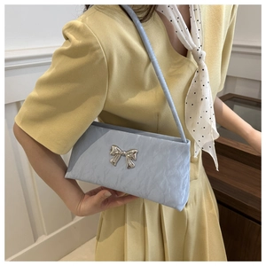 Détail du sac à bandoulière plissé bleu clair avec un nœud en métal argenté pour femme