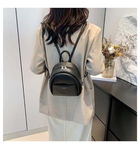 Gros plan sur un mini sac à dos noir en cuir PU texturé avec fermetures éclair argentées élégantes