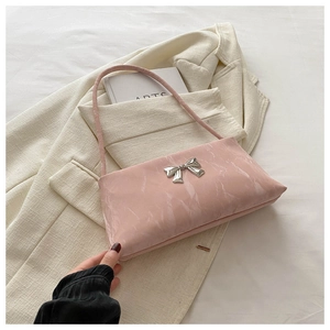 Détail du sac à bandoulière rose clair avec nœud métallique argenté et texture marbre