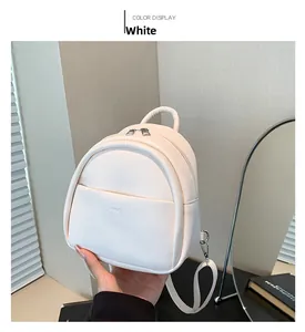 Détail du mini sac à dos blanc en cuir avec fermetures éclair argentées et bretelles