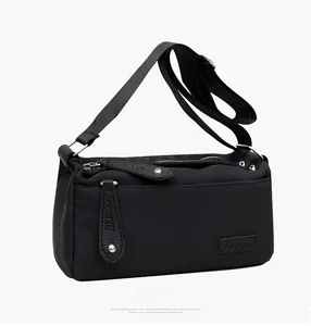 Detailed side view of black water-repellent nylon crossbody bag with lychee leather trim