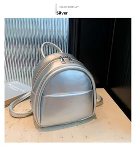 Détail d'un mini sac à dos argenté métallisé avec texture lisse et double fermeture