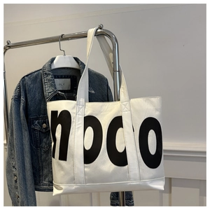 Détail du sac cabas blanc avec grand imprimé de lettres NOCO noires et texture cuir