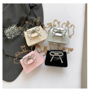 Detail of four stylish mini crossbody bags with decorative bow buckles and gold chain straps