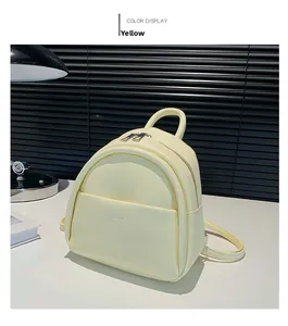 Détail macro du mini sac à dos jaune avec zips argentés et logo dimal sur fond blanc