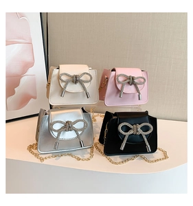 Detailed arrangement of mini crossbody bags with diamond bows and gold chain straps