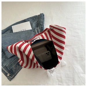 Macro view of canvas tote bag with red stripes, lace details and spacious interior