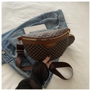 Détail du sac banane vintage marron avec petite pochette sur texture veste en jean