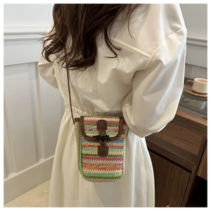 Detail view of woven multi-color crossbody phone bag with vintage wooden toggle closure