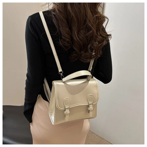Detail of cream leather backpack with dual buckles on model for size and style reference